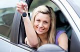 Attractive young driver holding a key after bying a new car 