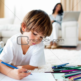 Concentrated little boy drawing and his sister eating chips 