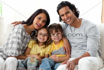 Lively family watching TV together sitting on a sofa