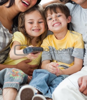 Adorable children watching TV with their parents
