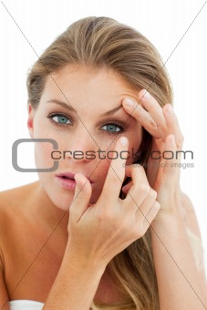 Concentrated woman putting a contact lens 