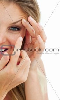 Charming woman putting a contact lens 