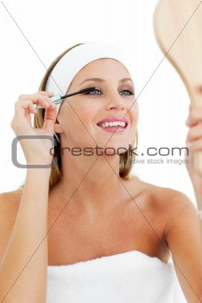 Smiling woman putting mascara