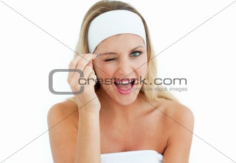 Young woman using tweezers