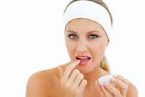 Attractive woman applying lip balm 