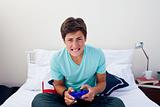 Teenager playing video games in his bedroom