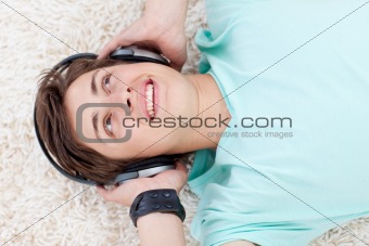 Cute teen guy listening to music with headphones