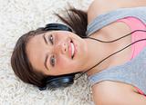 Cute teen girl listening to music on the floor