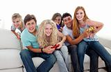 Cute teenagers having fun playing video games in the living-room