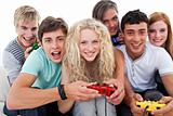 Excited teenagers having fun playing video games in the living-room