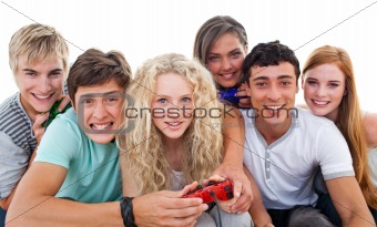 Excited teenagers playing video games in the living-room