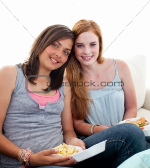 Young girls eating burgers and fries