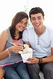 Smiling couple of teenagers eating pasta