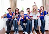 Teenagers watching a football match in the living-room