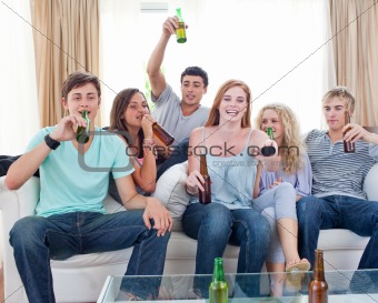 Friends drinking beer at home and watching tv