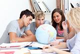 Teenagers in a library working with a terrestrial globe