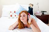 Beautiful teenager listening to the music on his bed