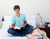 Smiling teenager studying maths in his bedroom