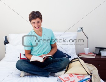 Smiling teenager studying maths in his bedroom