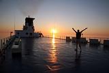Man enjoy sunrise on the liner during cruise 