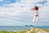 Attractive woman jumping of joy on tropical beach