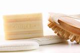 Natural soap with bath accessories on white