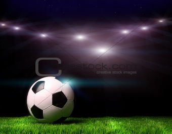 Soccer ball on grass against black