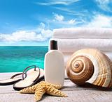 Sunblock lotion and towels and ocean scene