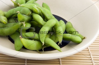 Plate of edamame on bamboo placemat