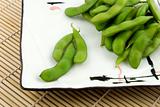 Plate of edamame on bamboo placemat