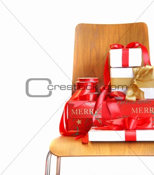 Pile of gifts on wooden chair against white