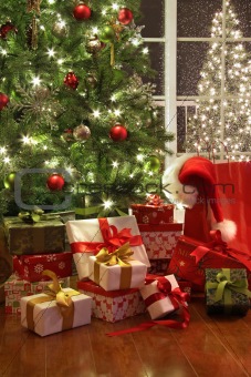 Brightly lit christmas tree with lots of gifts