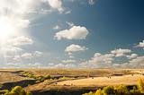 Big sun cloudy blue sky above an autumn landscape 