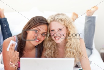 Portrait of teen girls shopping online in a bedroom