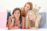 Happy teen girls after shopping clothes talking on mobile phone