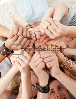 Teens relaxing on floor in a circle with thumbs up