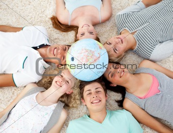 Teenagers on the floor with a terrestrial globe in the center