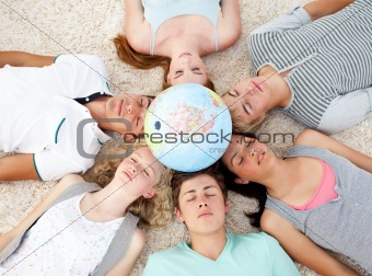 High angle of teenagers with their heads together sleeping on the ground at home