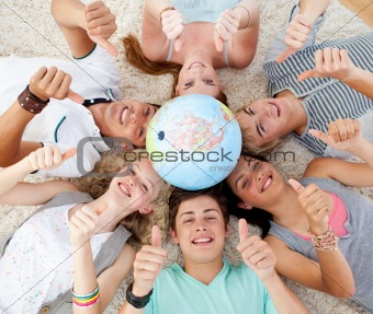 Teenagers on the floor with a terrestrial globe in the center an