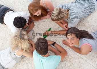 Group of friends playing spin the bottle