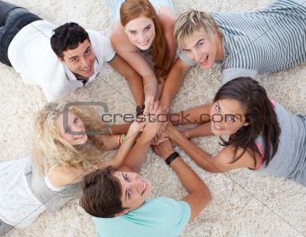Friends lying on the floor with hands together