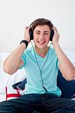 A teenage guy listening to the music in his bedroom