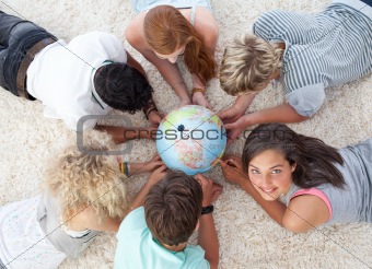 Group of friends on the floor examining a terrestrial world