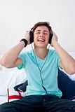 Teenager listening to the music in his bedroom with headphones