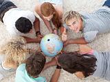 Group of teenagers on the floor examining a terrestrial world an