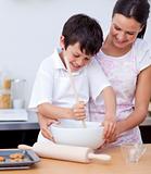 Adorable little boy preparing cookies with her mother
