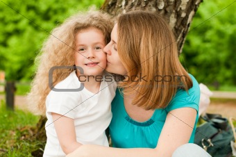 mother kissing her daughter