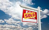 Sold For Sale Real Estate Sign over Clouds and Blue Sky with Sun Rays.