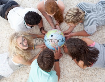 High angle of teenagers on the floor examining a terrestrial wor