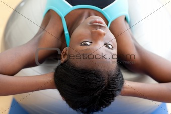Serious woman doing sit-ups with a pilates ball